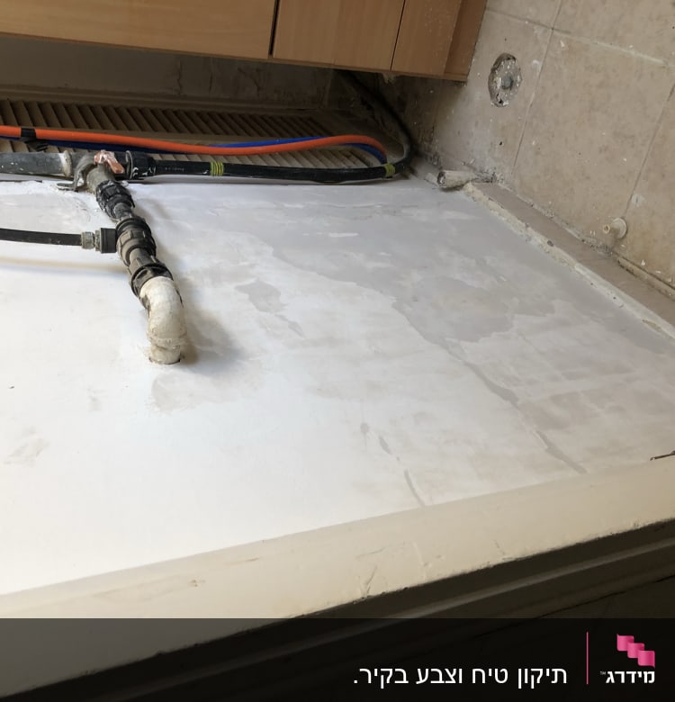 קיר צבוע בלבן עם צינורות חשופים